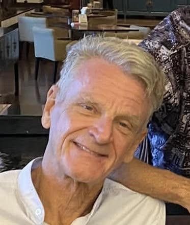 Dr. James Powell smiling in a white shirt